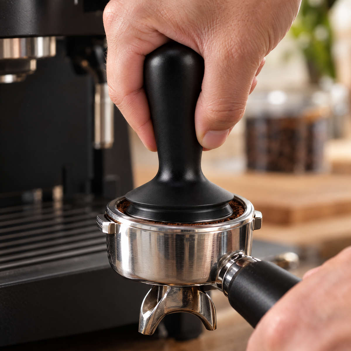 Tamping ground coffee level in a portafilter with a black tamper